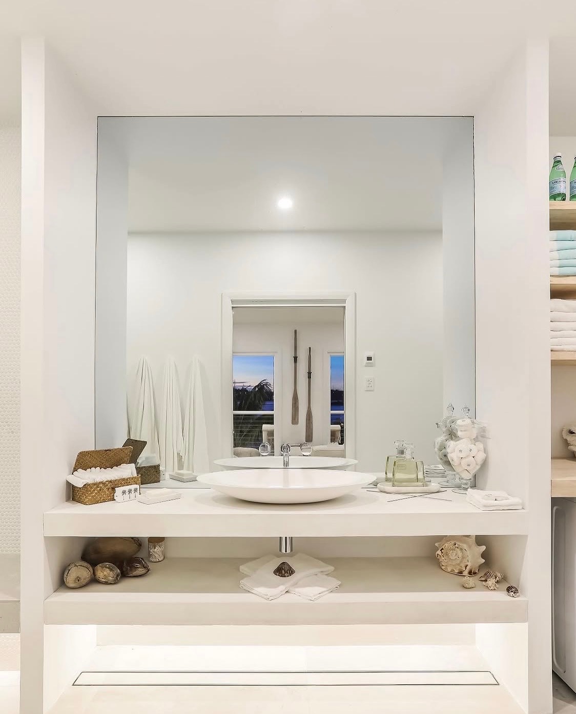 White vanity with mirror reflecting ocean view