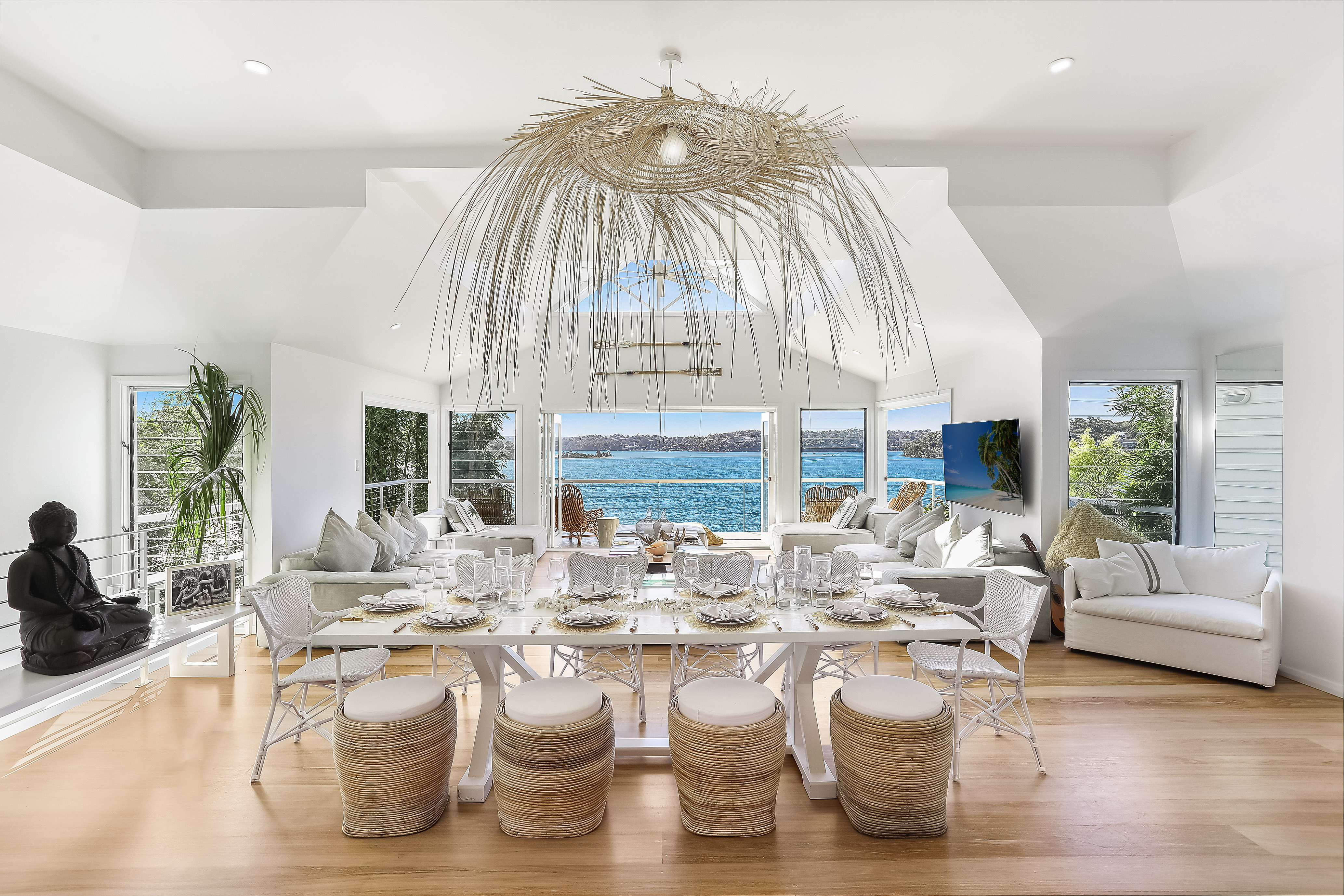 Dining room with oversized raffia sunburst chandelier and panoramic ocean view